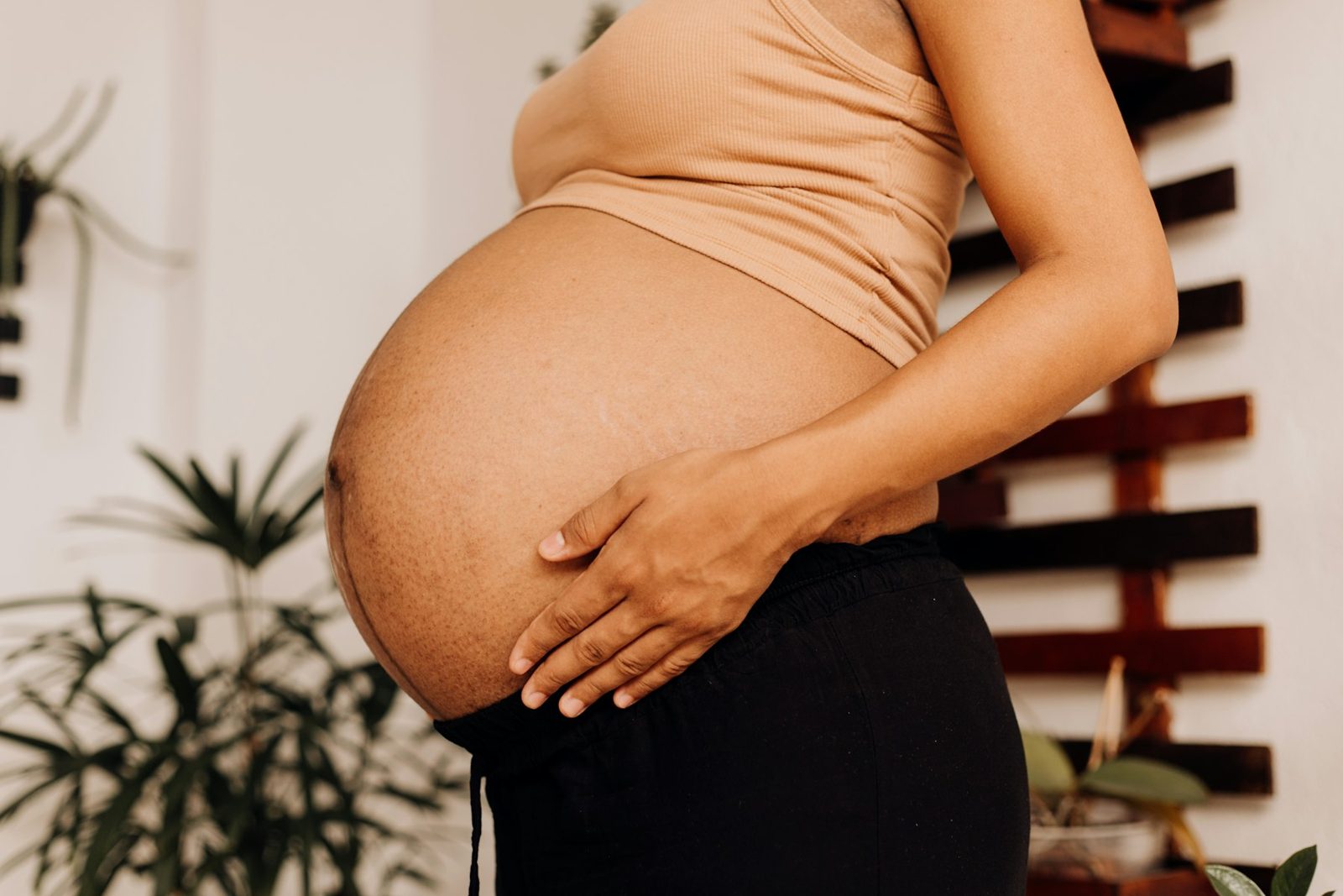 A pregnant woman resting her hands on her belly